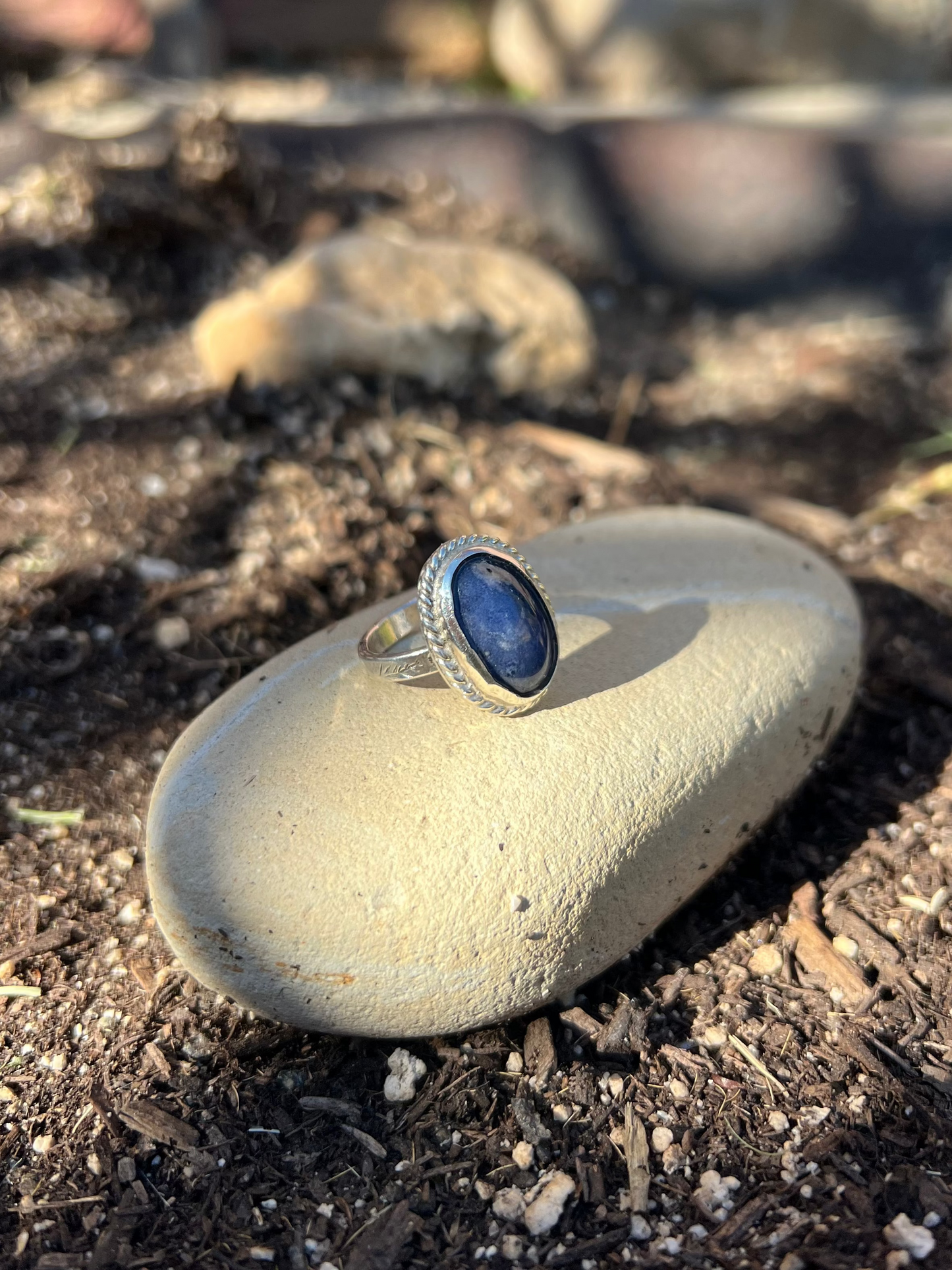 Ring with a blue stone on a rock in a natural setting