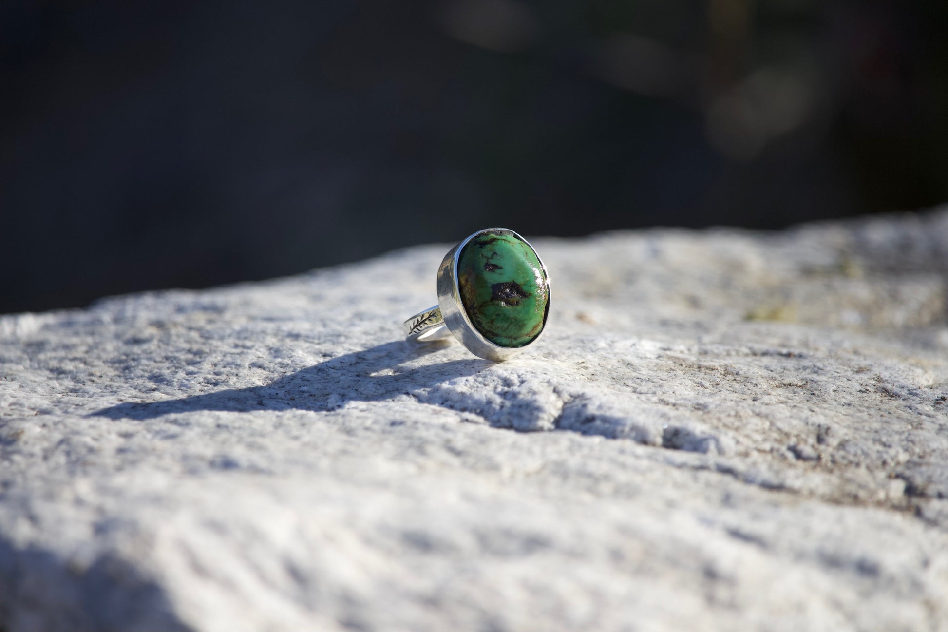 Ring with a green stone on a textured surface