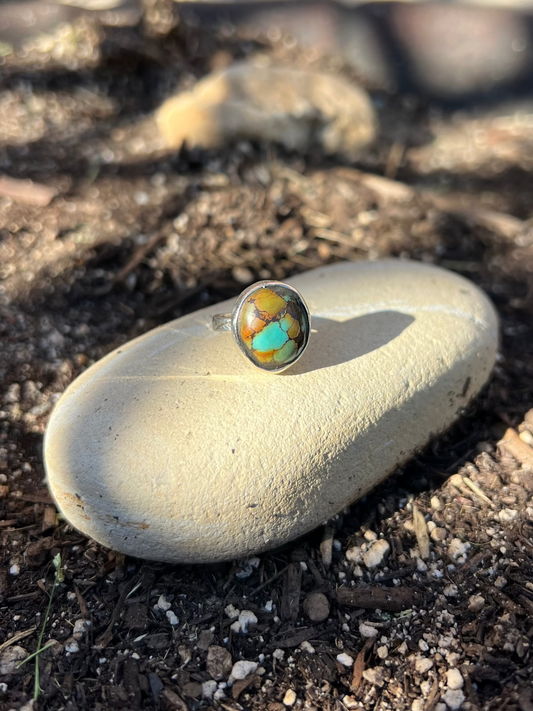 Turquoise stone on a rock with a blurred natural background