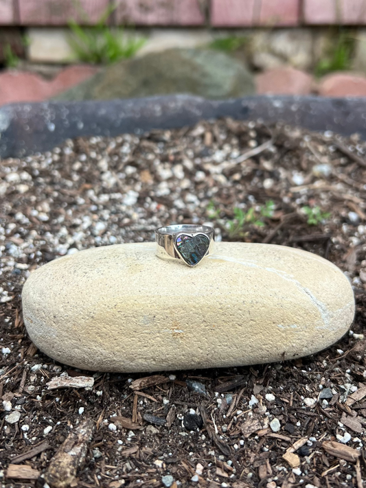 Heart-shaped ring on a rock with a natural outdoor background