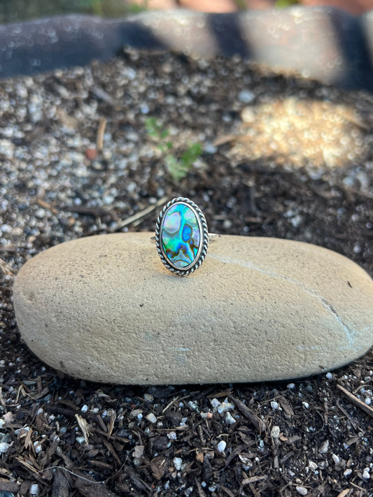 Ring with a colorful stone on a rock in a natural setting