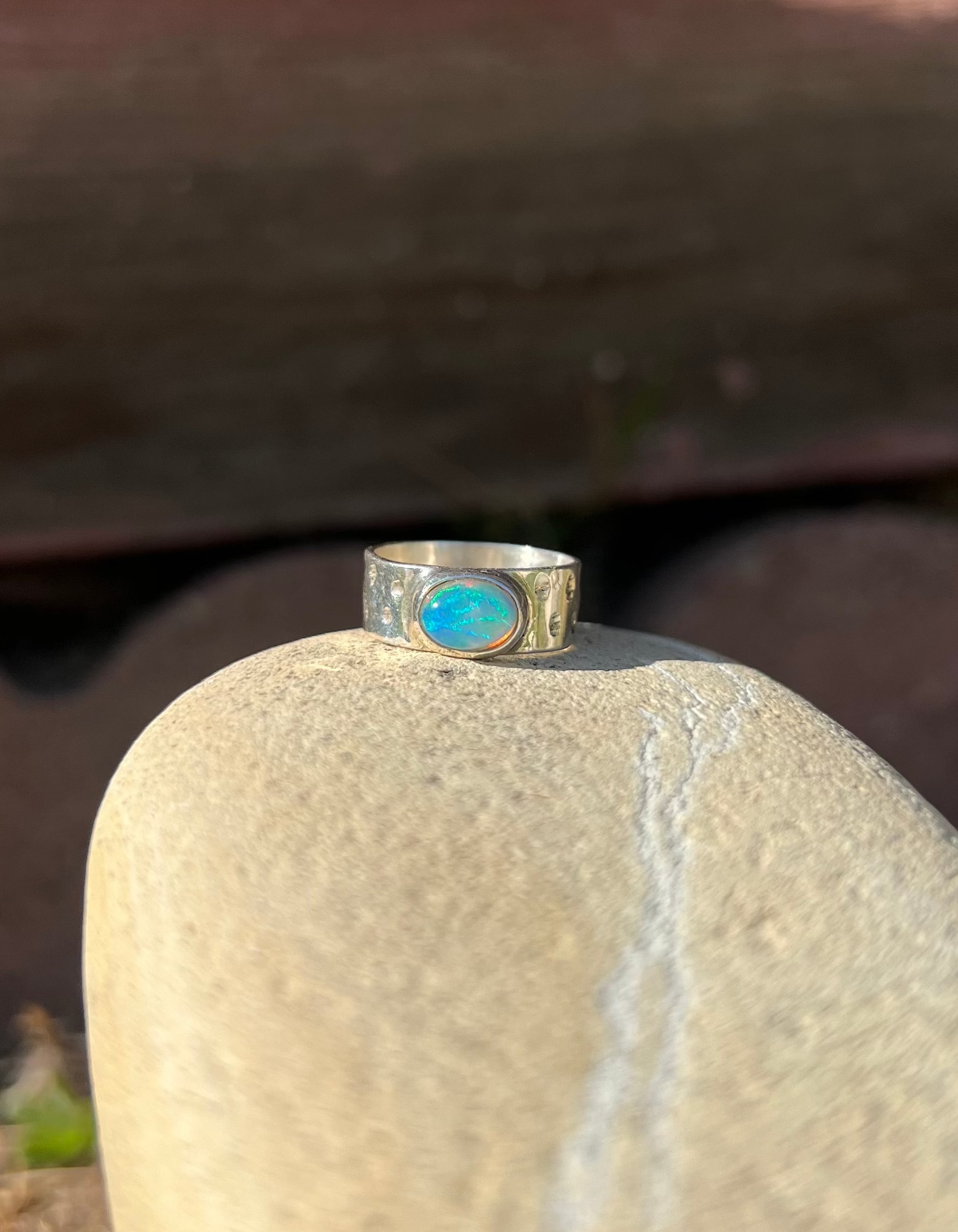 Silver ring with a blue stone on a beige rock