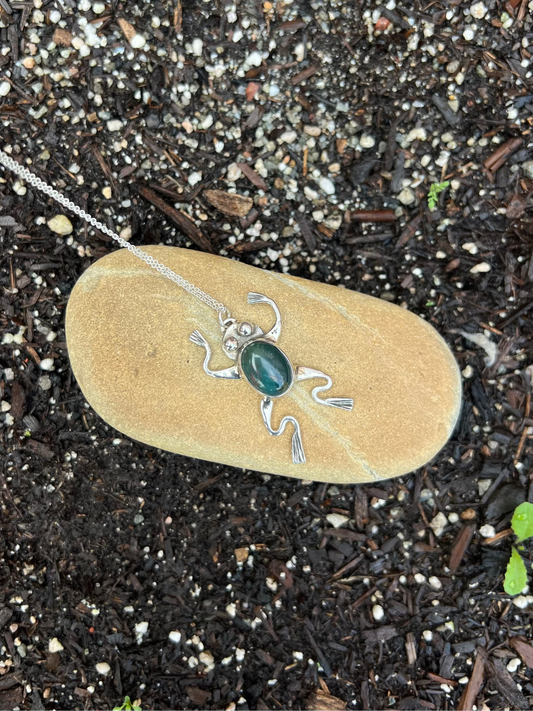 Necklace with a pendant on a rock in soil