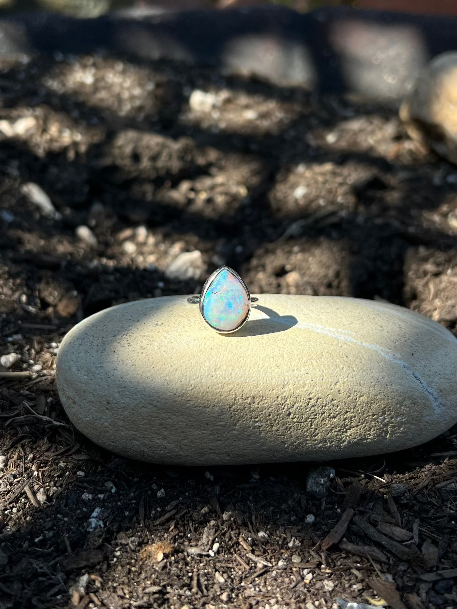 Opal ring on a stone in a garden setting