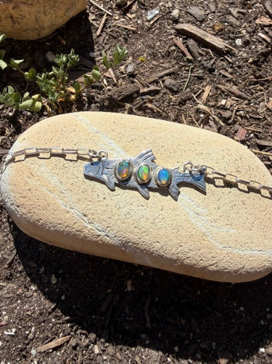 Necklace with a fish pendant on a rock outdoors