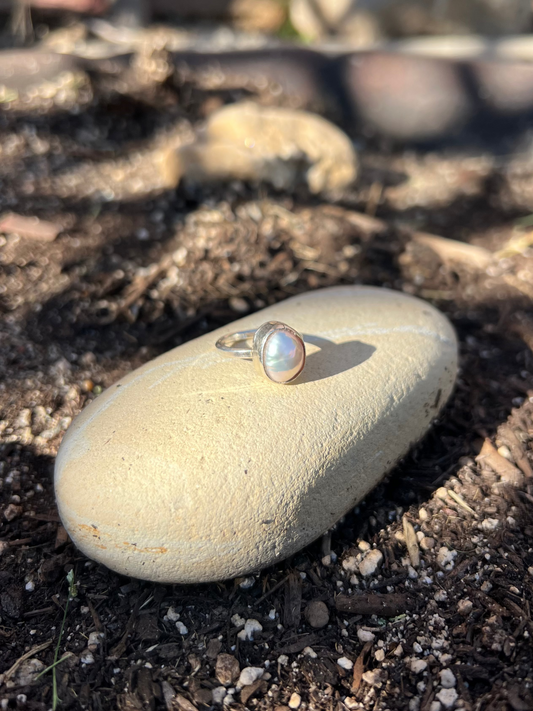Ring with a pearl on a stone in an outdoor setting