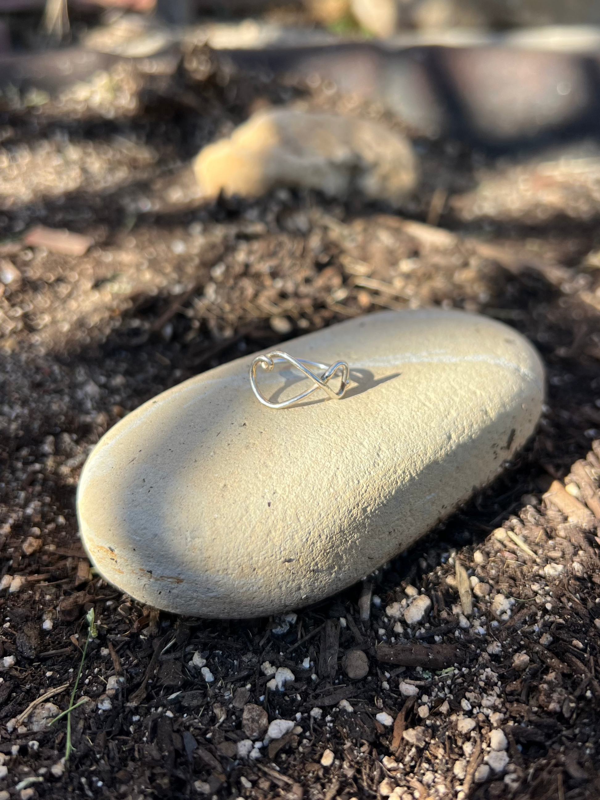 Small silver ring on a rock in an outdoor setting