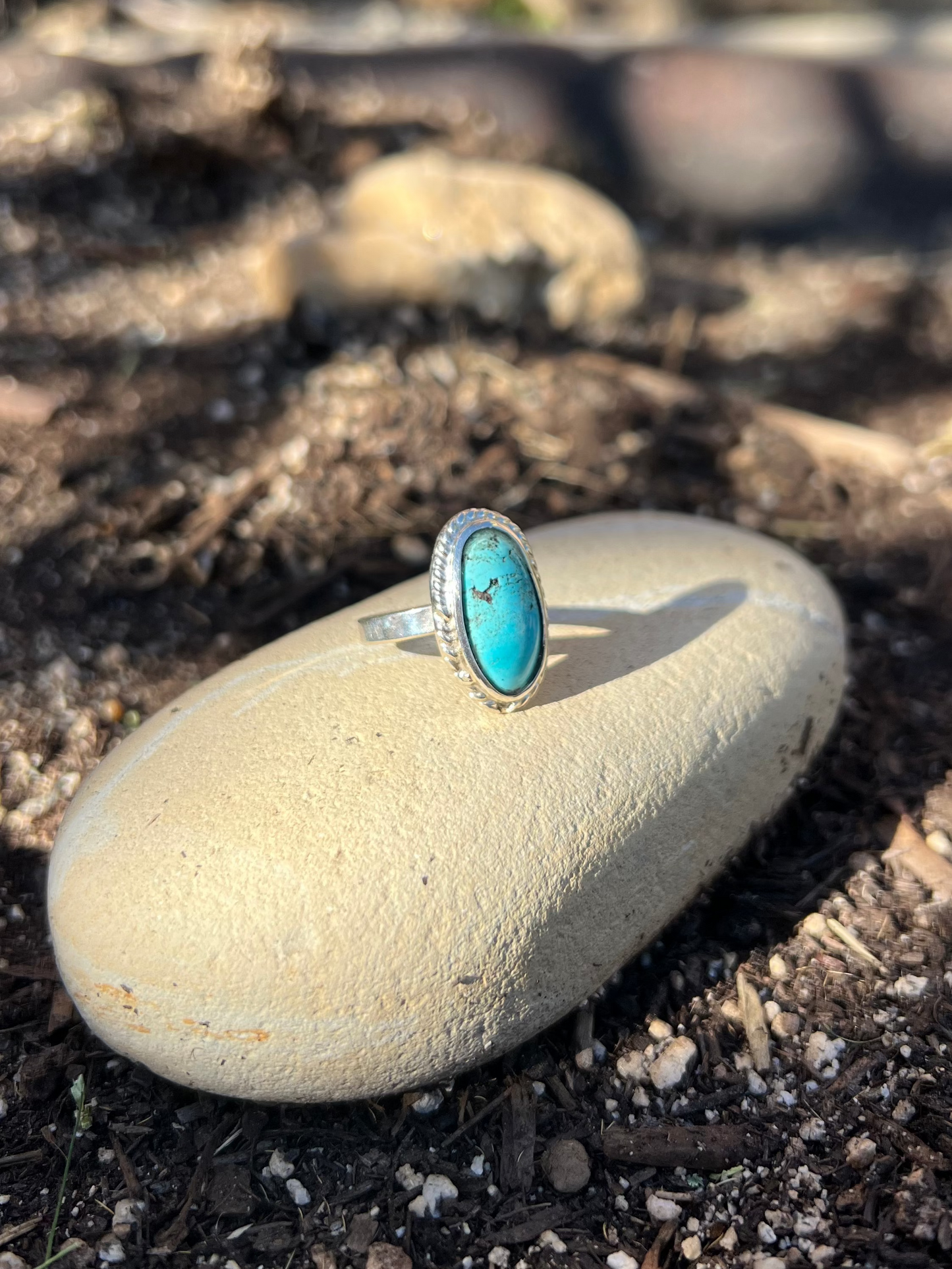 Turquoise ring on a rock with a natural outdoor background