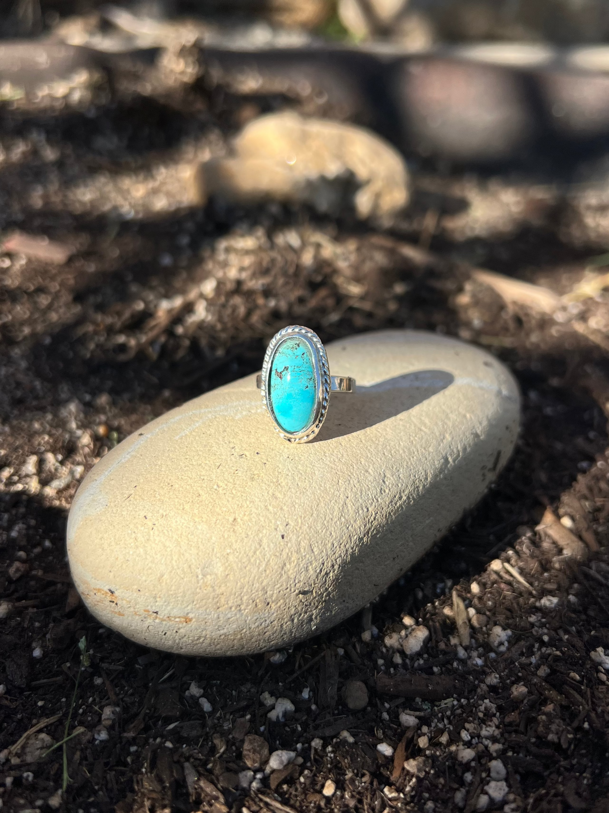 Turquoise ring on a pebble with a natural background